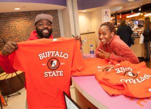 Student holding up a Buffalo State T-shirt