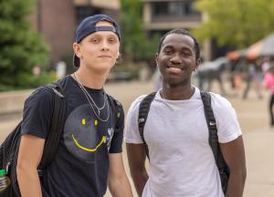 Two smiling students posing in the Plaza