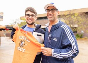 Prospective student displays a Buffalo State T-shirt in the Plaza