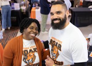 Smiling woman and man wearing Bengals Roar to Success T-shirts give thumbs-up to camera