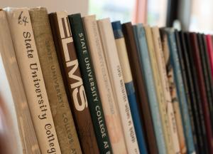 Several years' worth of Elms yearbooks lined up in a row