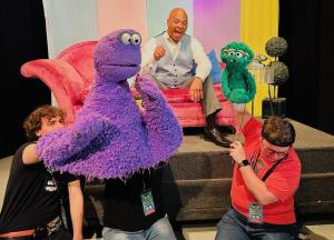 Actor and puppeteers film a scene with puppets for the 'Be Happy' pilot