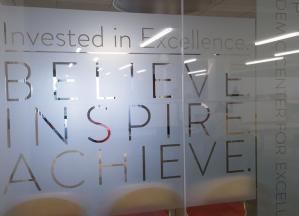 Believe Inspire Achieve etched onto glass panel in Academic Commons