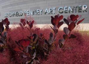 Exterior shot of the Burchfield Penney Art Center from ground level with foliage in the foreground