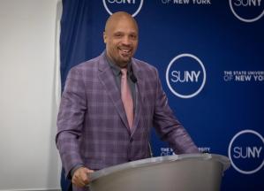 Chance Glenn at a lectern with a SUNY backdrop