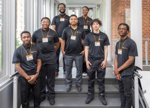 LSAMP students wearing black Buffalo State T-shirts posing on a staircase