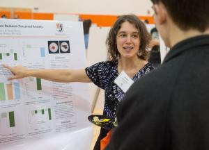 Faculty member discussing a research poster presentation at the Fall Forum