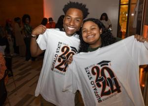 Two smiling students holding Buffalo State Class of 2024 T-shirts