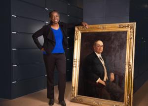 Sheila Rayam poses with life-size portrait of E. H. Butler Sr.