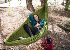 Student relaxing in a hammock on campus