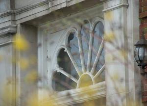 Detail of fan light window in Bacon Hall with spring buds in the foreground