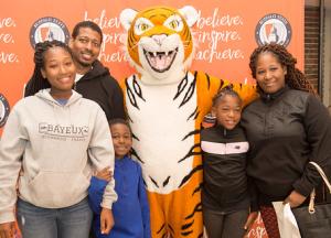 Family poses with Benji mascot at Open House