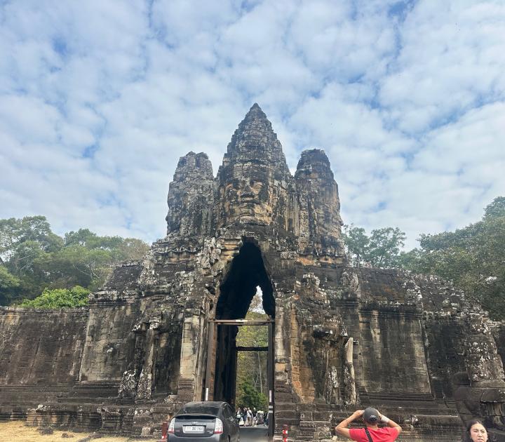 A cement structure in Southeast Asia framed by a blue sky and trees